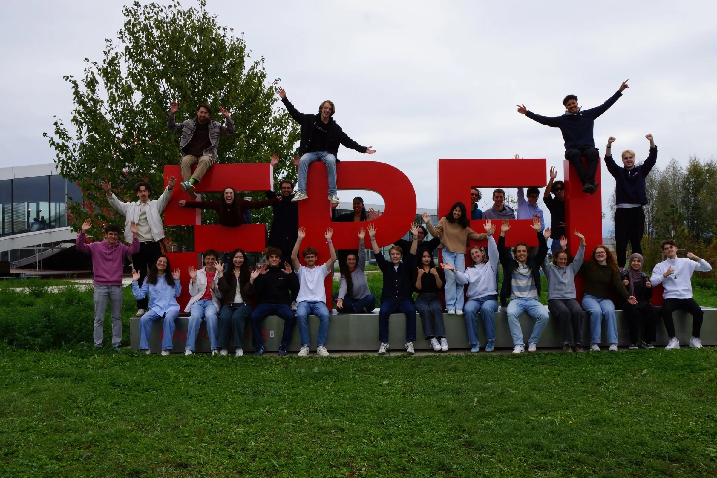The 2026–2027 Carbon Team waving in front of the EPFL sign on campus